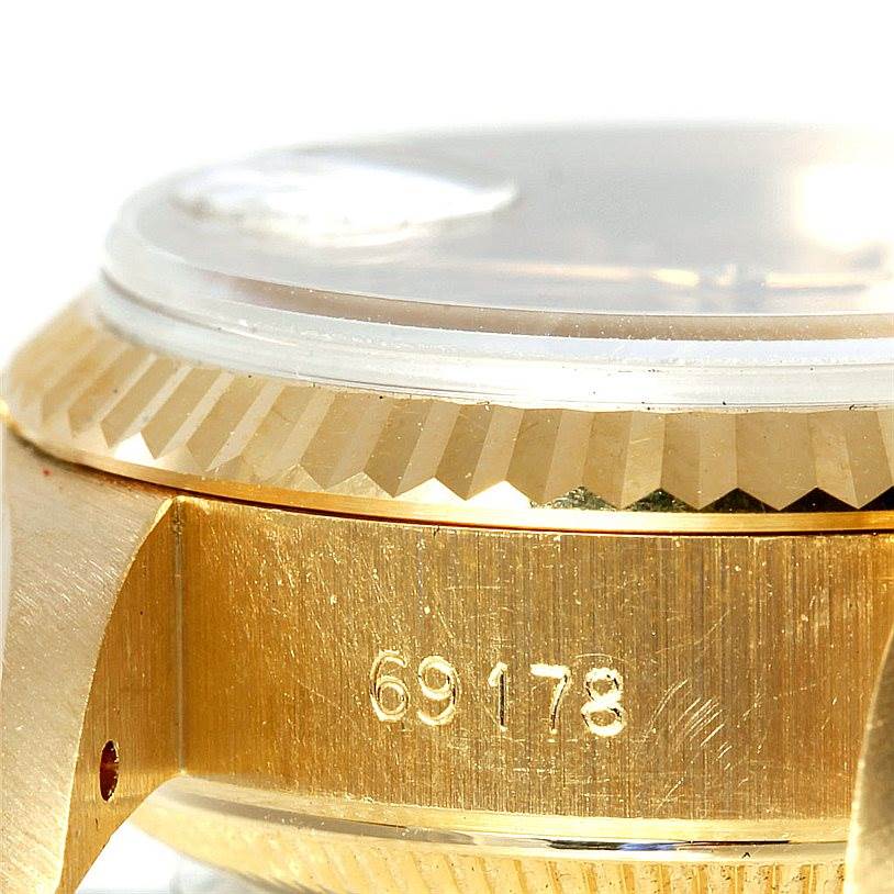 This image shows a side view of the Rolex President 69178 Women's Yellow Gold Champagne Dial 69178 Women's Yellow Gold Champagne Dial watch model, highlighting the serial number and part of the watch case and bezel.