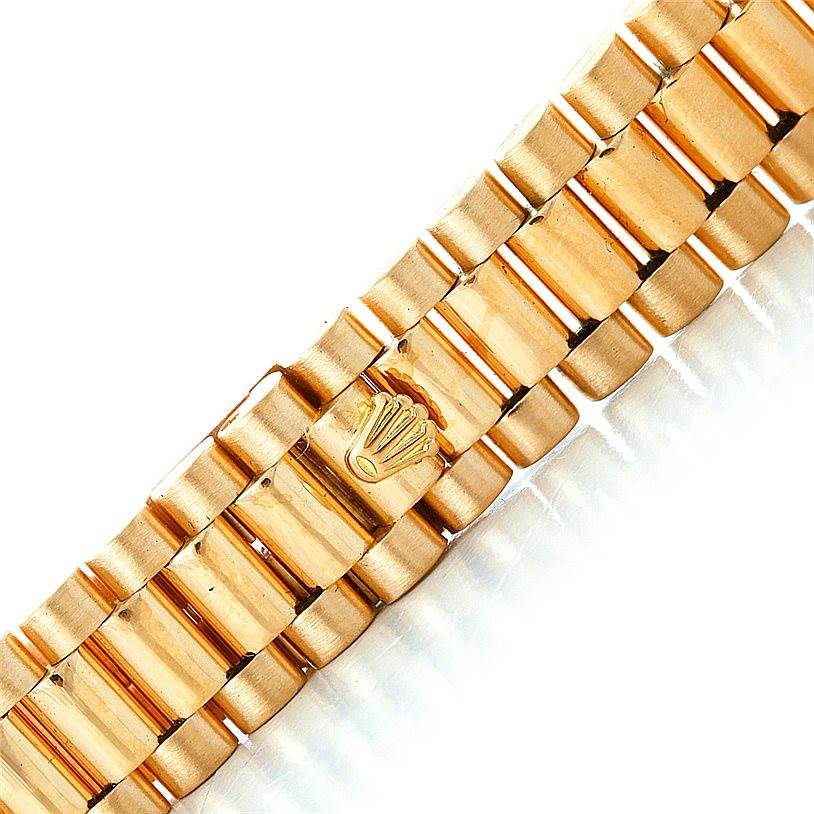 The image shows a close-up of the bracelet of a Rolex President 6917 Women's Yellow Gold Brown Dial 6917 Women's Yellow Gold Brown Dial model watch, featuring the iconic Rolex crown.