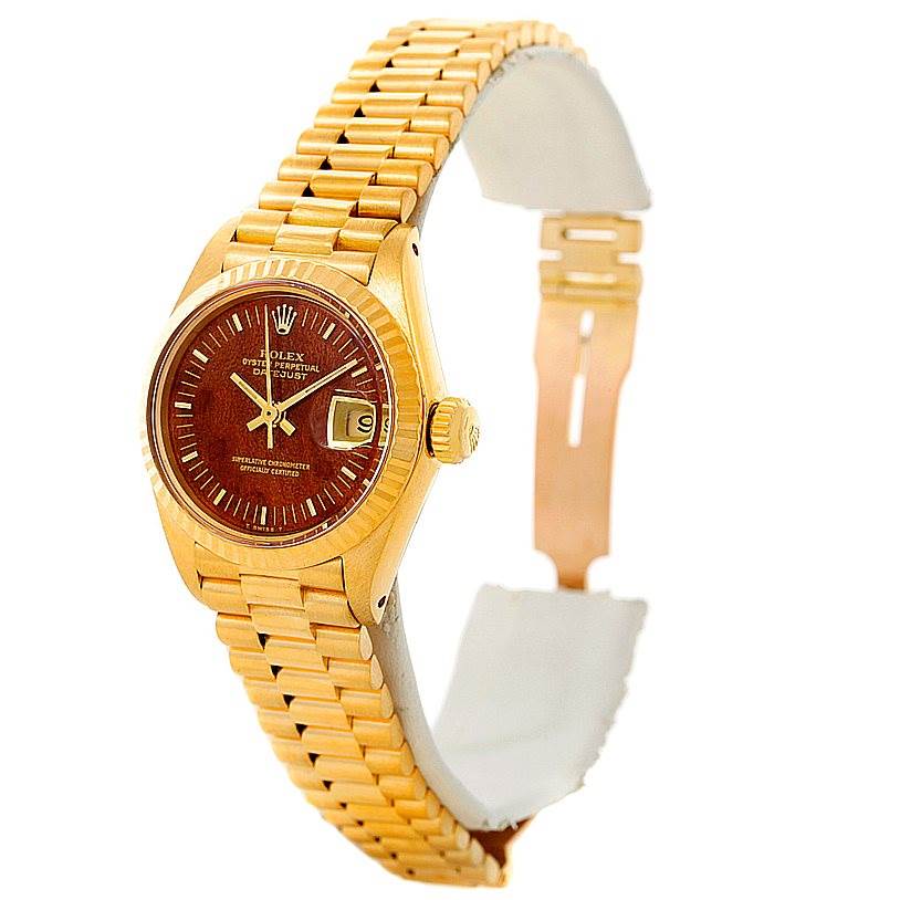 The Rolex President 6917 Women's Yellow Gold Brown Dial 6917 Women's Yellow Gold Brown Dial model watch is shown in a partially side view, displaying its face, bracelet, and partially open clasp.