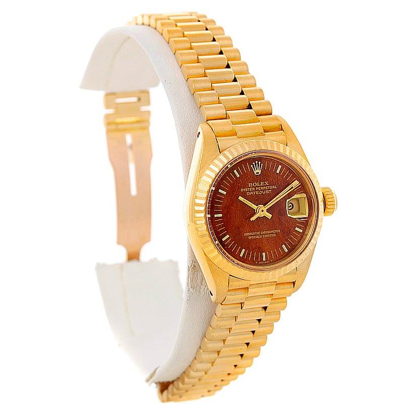 The image shows a side view of a Rolex President 6917 Women's Yellow Gold Brown Dial 6917 Women's Yellow Gold Brown Dial model watch, highlighting the gold bracelet, bezel, and wooden dial.