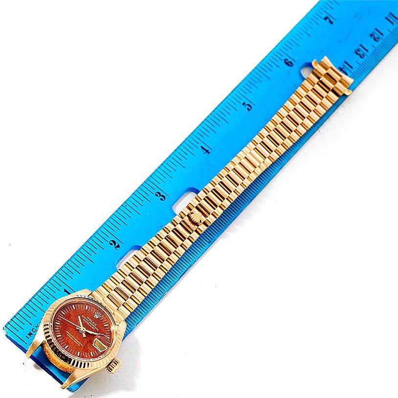 The image shows a Rolex President 6917 Women's Yellow Gold Brown Dial 6917 Women's Yellow Gold Brown Dial model watch, including the dial, case, and bracelet, laid flat next to a blue ruler for scale.