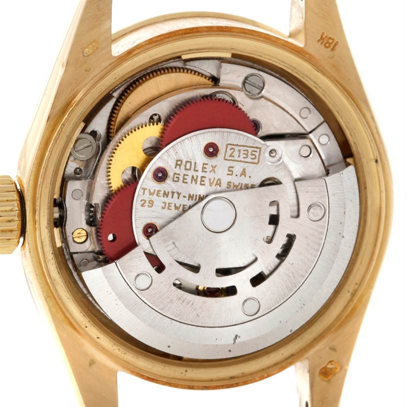 The image shows the backside and internal mechanism of a Rolex President 69178 Women's Yellow Gold Champagne Dial 69178 Women's Yellow Gold Champagne Dial model watch, revealing gears and the rotor.