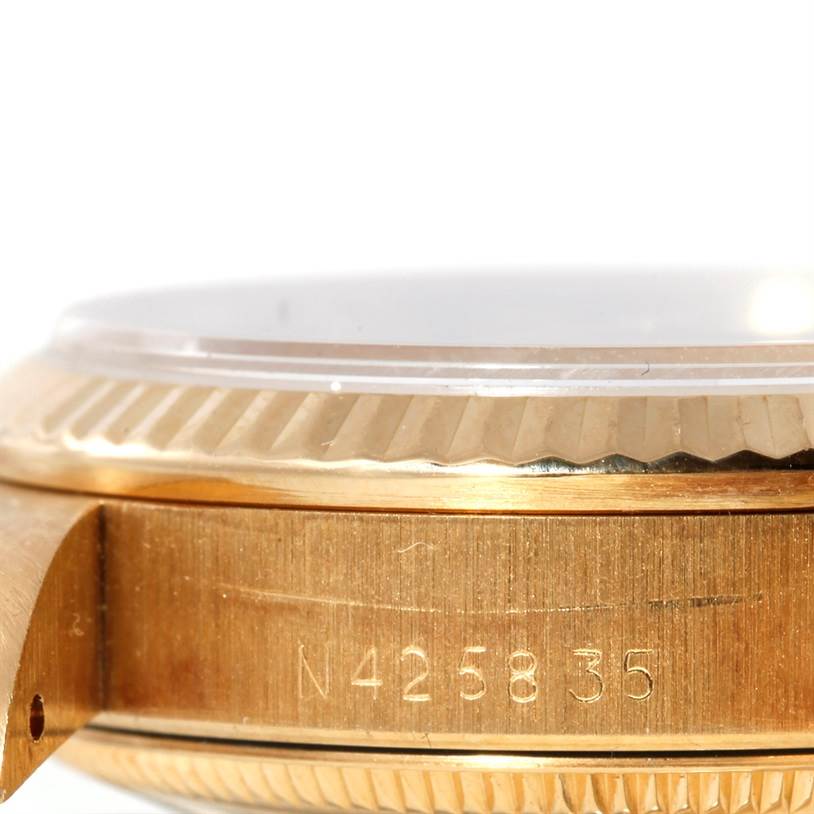 This close-up image showcases the side view of the Rolex President 68278 Women's Yellow Gold Champagne Dial 68278 Women's Yellow Gold Champagne Dial model watch, highlighting the fluted bezel and part of the case with an engraved serial number.