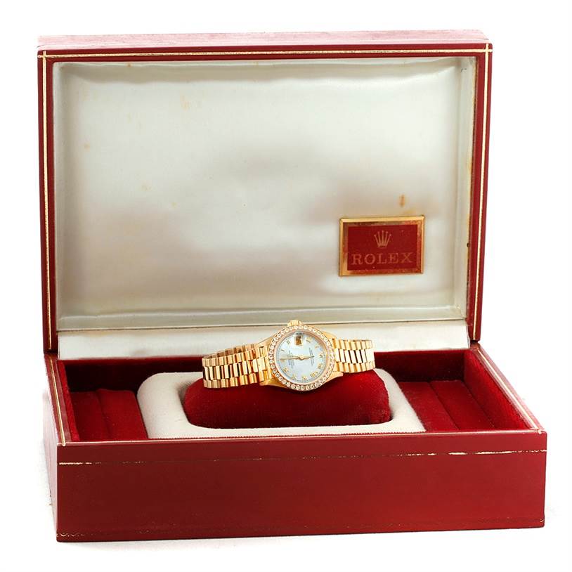 The Rolex President 69178 Women's Yellow Gold Mother of Pearl Dial 69178 Women's Yellow Gold Mother of Pearl Dial model watch is displayed inside an open red and white jewelry box.