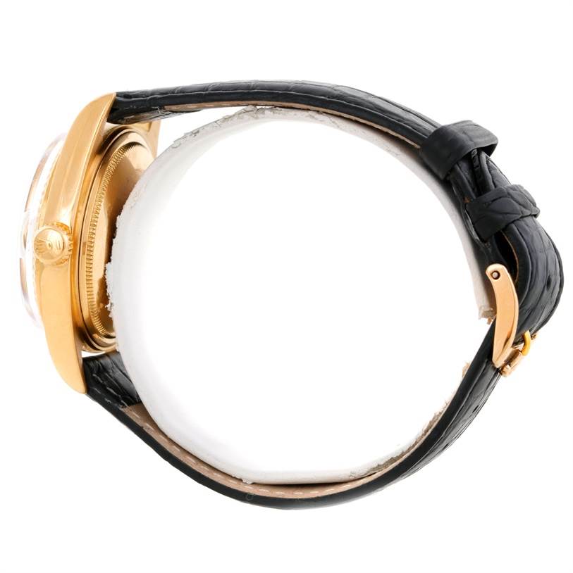 This side view of the Rolex President 1803 Men
s Yellow Gold Silver Dial 1803 Men
s Yellow Gold Silver Dial model watch shows its bezel, crown, and black leather strap with buckle.