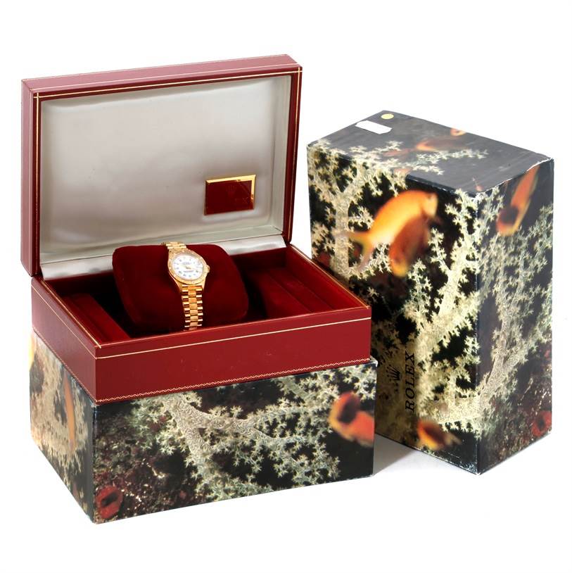 The Rolex President 69288 Women's Yellow Gold White Dial 69288 Women's Yellow Gold White Dial watch is shown from a frontal angle in an open display case with an outer decorative box beside it.