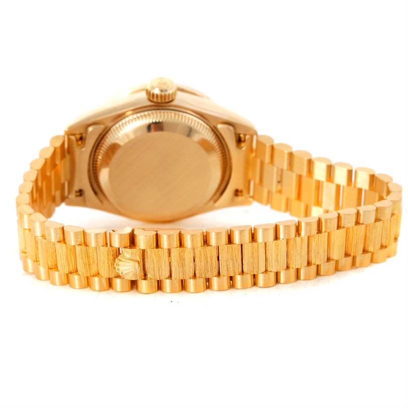 The image shows the back case and bracelet of a Rolex President 69288 Women's Yellow Gold White Dial 69288 Women's Yellow Gold White Dial model watch, highlighting its gold finish and crown clasp.