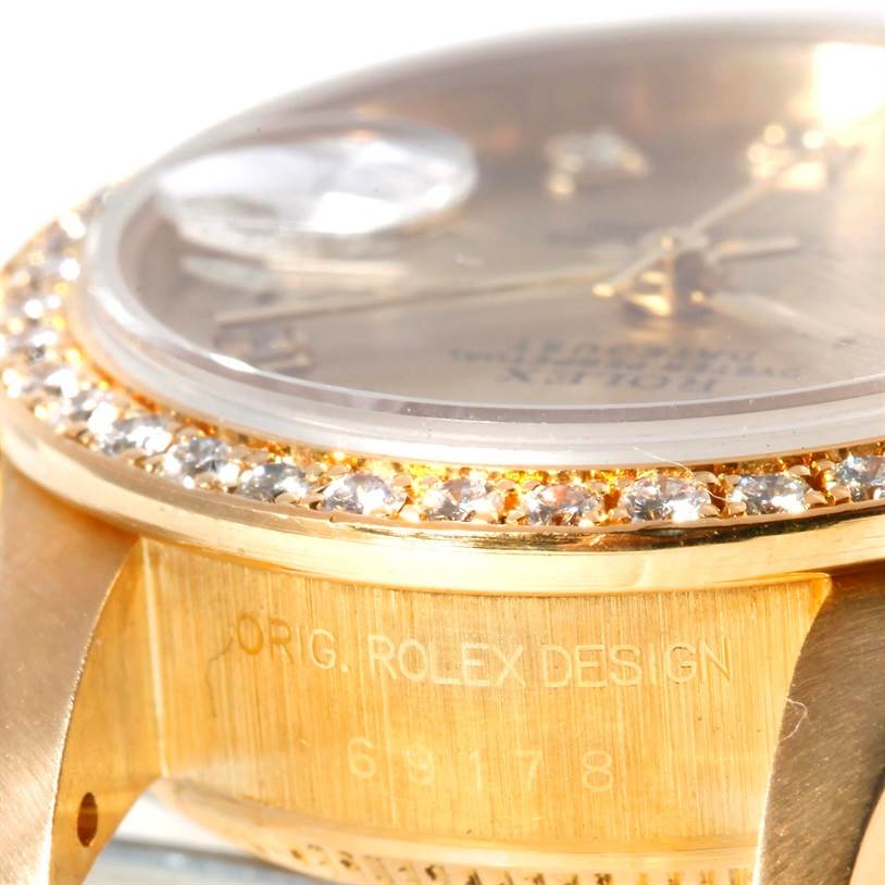 The image shows a close-up of the Rolex President 69178 Women's Yellow Gold Champagne Dial 69178 Women's Yellow Gold Champagne Dial watch, highlighting the diamond bezel and side engraving.