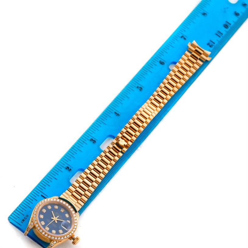 The image shows a Rolex President 69188 Women's Yellow Gold Blue Dial 69188 Women's Yellow Gold Blue Dial model watch with a gold band, measured against a blue ruler for scale.
