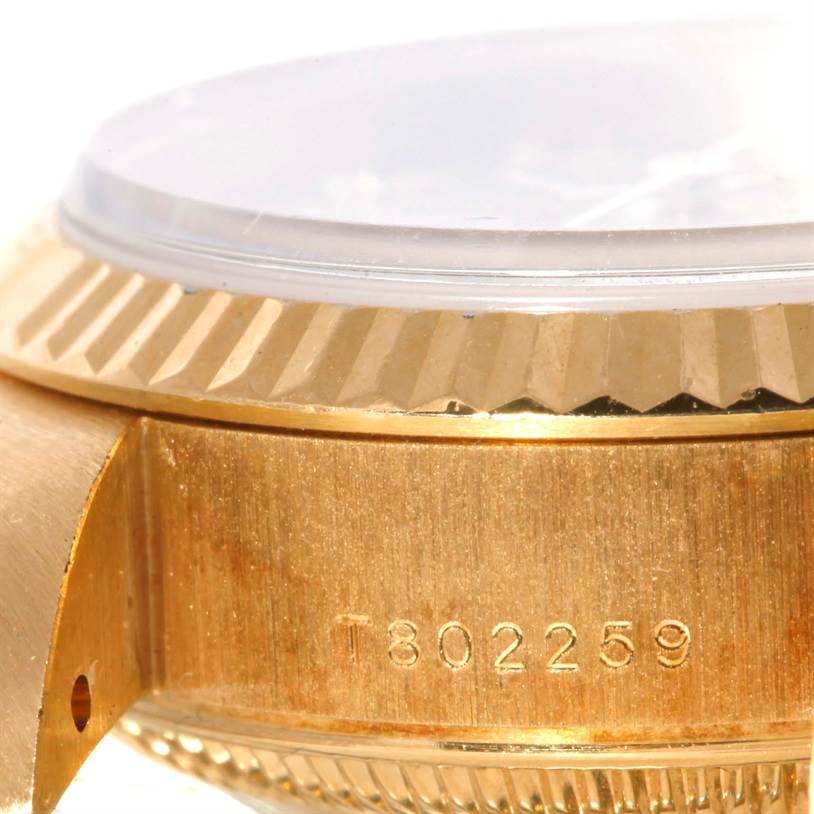 This image shows a close-up side angle of the Rolex President 69178 Women's Yellow Gold Champagne Dial 69178 Women's Yellow Gold Champagne Dial model, highlighting the gold case and part of the bezel with a serial number.