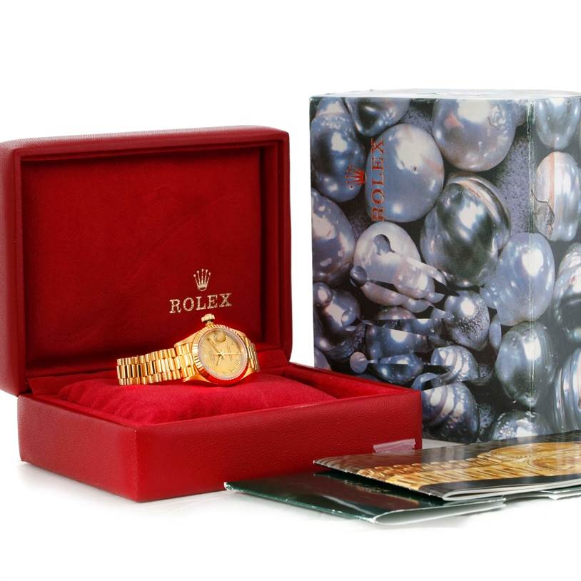 The Rolex President 69178 Women's Yellow Gold Champagne Dial 69178 Women's Yellow Gold Champagne Dial model is shown in its red box, with the outer box and booklets displayed beside it.