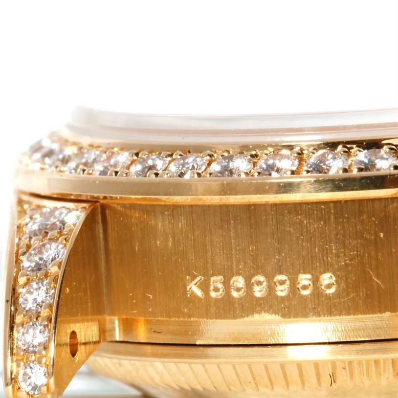 This close-up image shows a portion of the bezel and case with diamonds of a Rolex President 179298 Women's Yellow Gold Silver Dial 179298 Women's Yellow Gold Silver Dial model watch with its serial number.