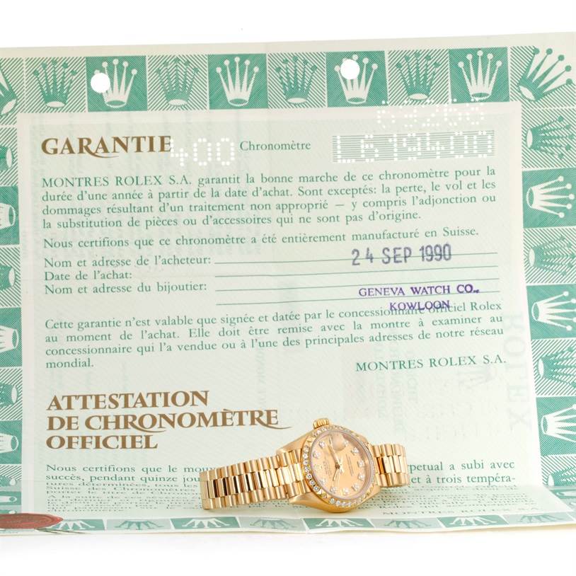 The image shows a Rolex President 69268 Women's Yellow Gold Champagne Dial 69268 Women's Yellow Gold Champagne Dial model watch alongside its warranty certificate, both captured from a top-down angle.