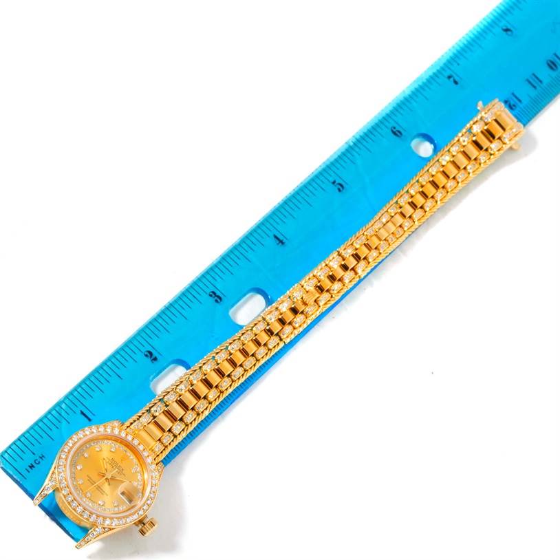 The image shows a Rolex President 69238 Women's Yellow Gold Champagne Dial 69238 Women's Yellow Gold Champagne Dial watch placed next to a blue ruler, viewed from a top-down angle.