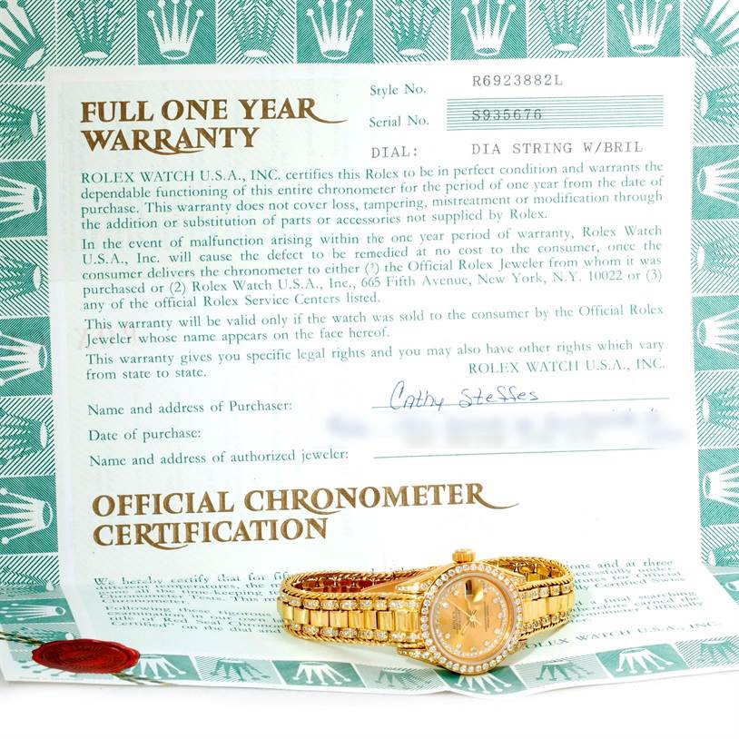 The image shows a Rolex President 69238 Women's Yellow Gold Champagne Dial 69238 Women's Yellow Gold Champagne Dial model watch lying flat on its side, next to its official warranty and certification documents.