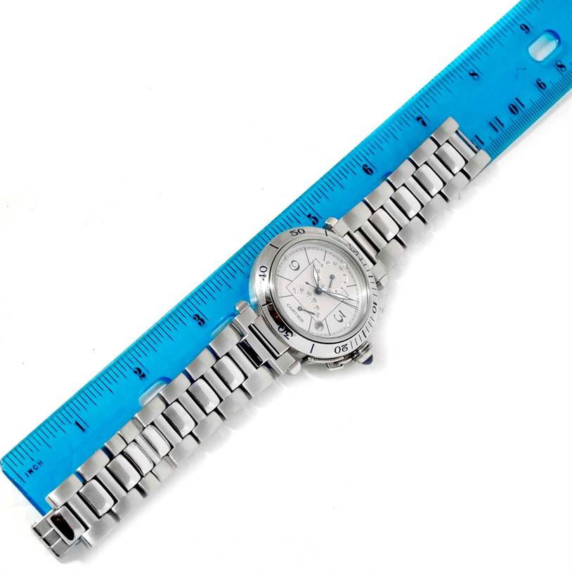 The Cartier Pasha W31037H3 Men's Stainless Steel Silver Dial W31037H3 Men's Stainless Steel Silver Dial watch is shown from a top-down angle, displaying its dial, case, and bracelet alongside a blue ruler.