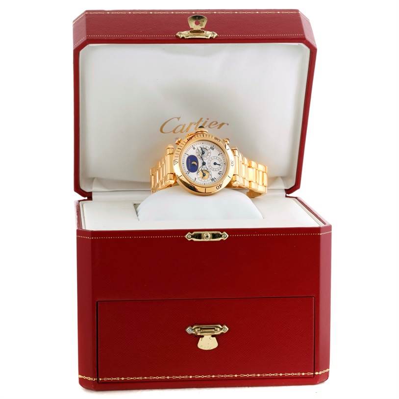 The Cartier Pasha M205025 Men's Yellow Gold Silver Dial M205025 Men's Yellow Gold Silver Dial watch is displayed frontally inside an open red and white Cartier box.
