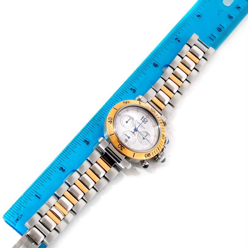 The Cartier Pasha W31036T6 Stainless Steel Silver Dial W31036T6 Stainless Steel Silver Dial watch shown is positioned diagonally with a metal band and ruler for scale.