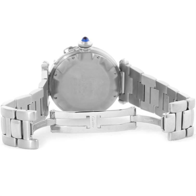 The image shows the back case and partially open metal bracelet of a Pasha model by Cartier.