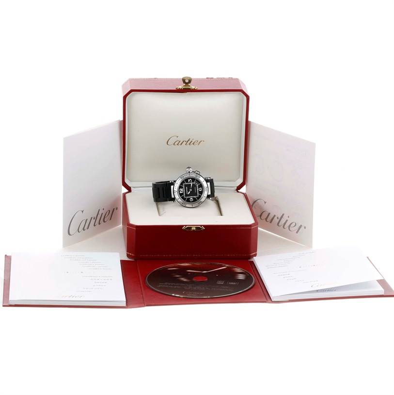 The Cartier Pasha W31077U2 Men's Stainless Steel Black Dial W31077U2 Men's Stainless Steel Black Dial watch is shown front-facing in its box, with booklets, a CD, and packaging displayed around it.