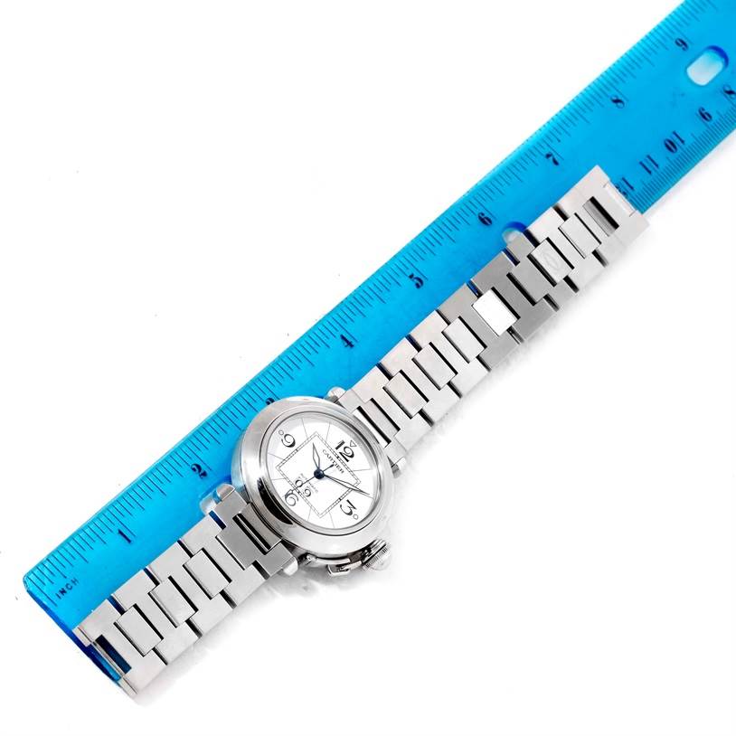 The Cartier Pasha W31055M7 Men's Stainless Steel White Dial W31055M7 Men's Stainless Steel White Dial watch is shown from a top-down angle, next to a blue ruler for scale.