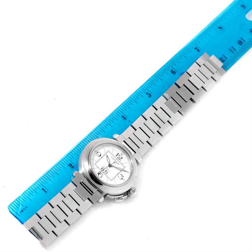 The Cartier Pasha W31055M7 Men
s Stainless Steel White Dial W31055M7 Men
s Stainless Steel White Dial watch is shown from a top-down angle alongside a blue ruler for scale.
