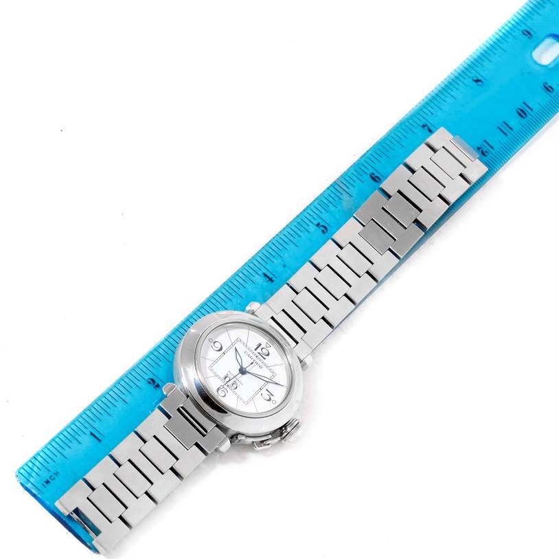 The Cartier Pasha W31055M7 Men
s Stainless Steel White Dial W31055M7 Men
s Stainless Steel White Dial watch is shown from a top-down angle, alongside a blue ruler for measurement.