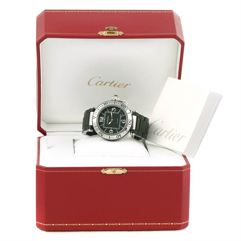 The image displays a Cartier Pasha W31077U2 Men's Stainless Steel Black Dial W31077U2 Men's Stainless Steel Black Dial watch at a front angle, inside an open red Cartier box with accompanying booklets.
