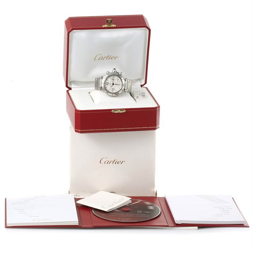This image shows a Cartier Pasha W31089M7 Men
s Stainless Steel Silver Dial W31089M7 Men
s Stainless Steel Silver Dial watch in an open red box, with accompanying documents and a disc displayed in front.
