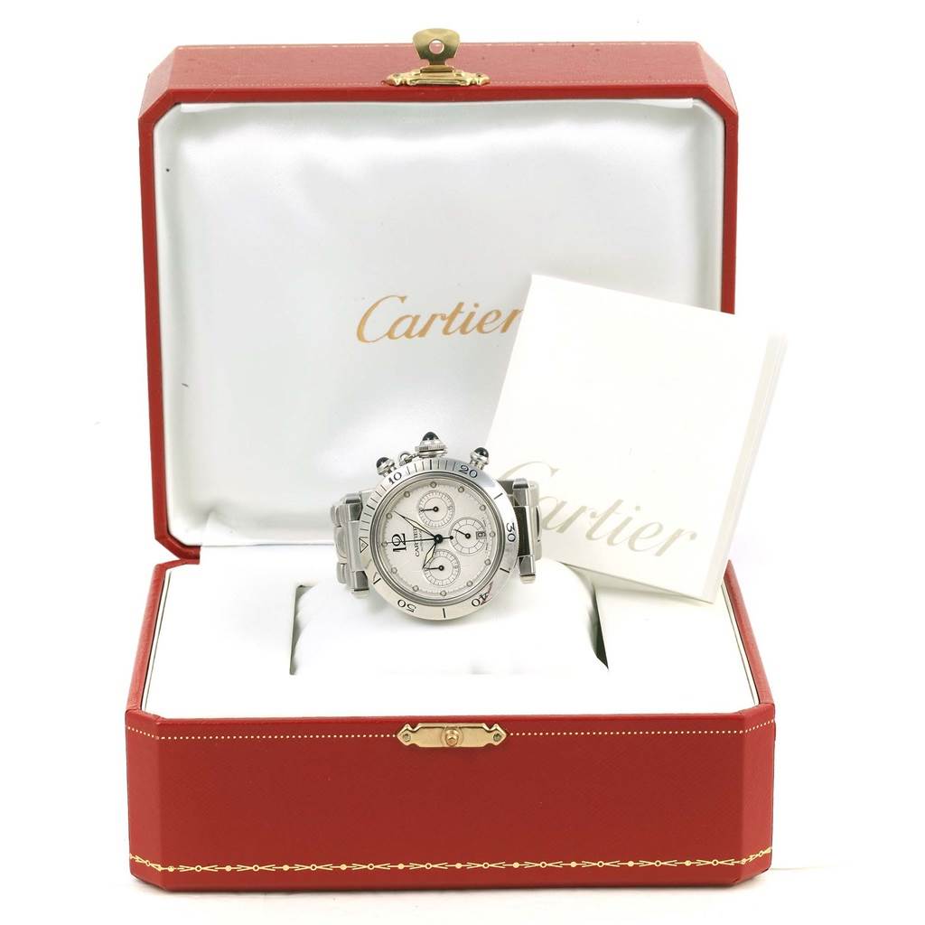 The Cartier Pasha W31030H3 Men
s Stainless Steel Silver Dial W31030H3 Men
s Stainless Steel Silver Dial watch is displayed frontally in an open red box with a folded booklet next to it.