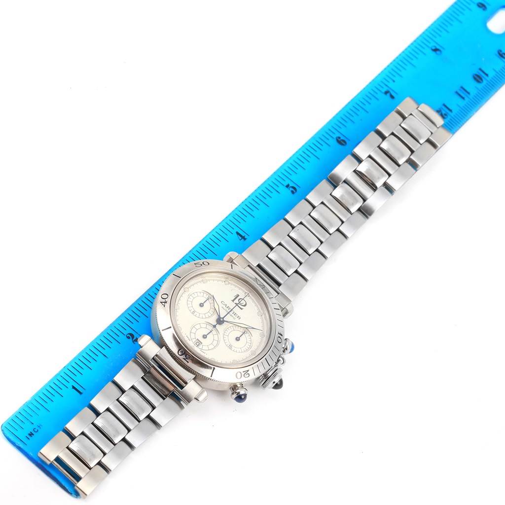 The Cartier Pasha W31030H3 Men
s Stainless Steel Silver Dial W31030H3 Men
s Stainless Steel Silver Dial watch is shown flat with its face, bezel, and metal bracelet visible, measured against a blue ruler.