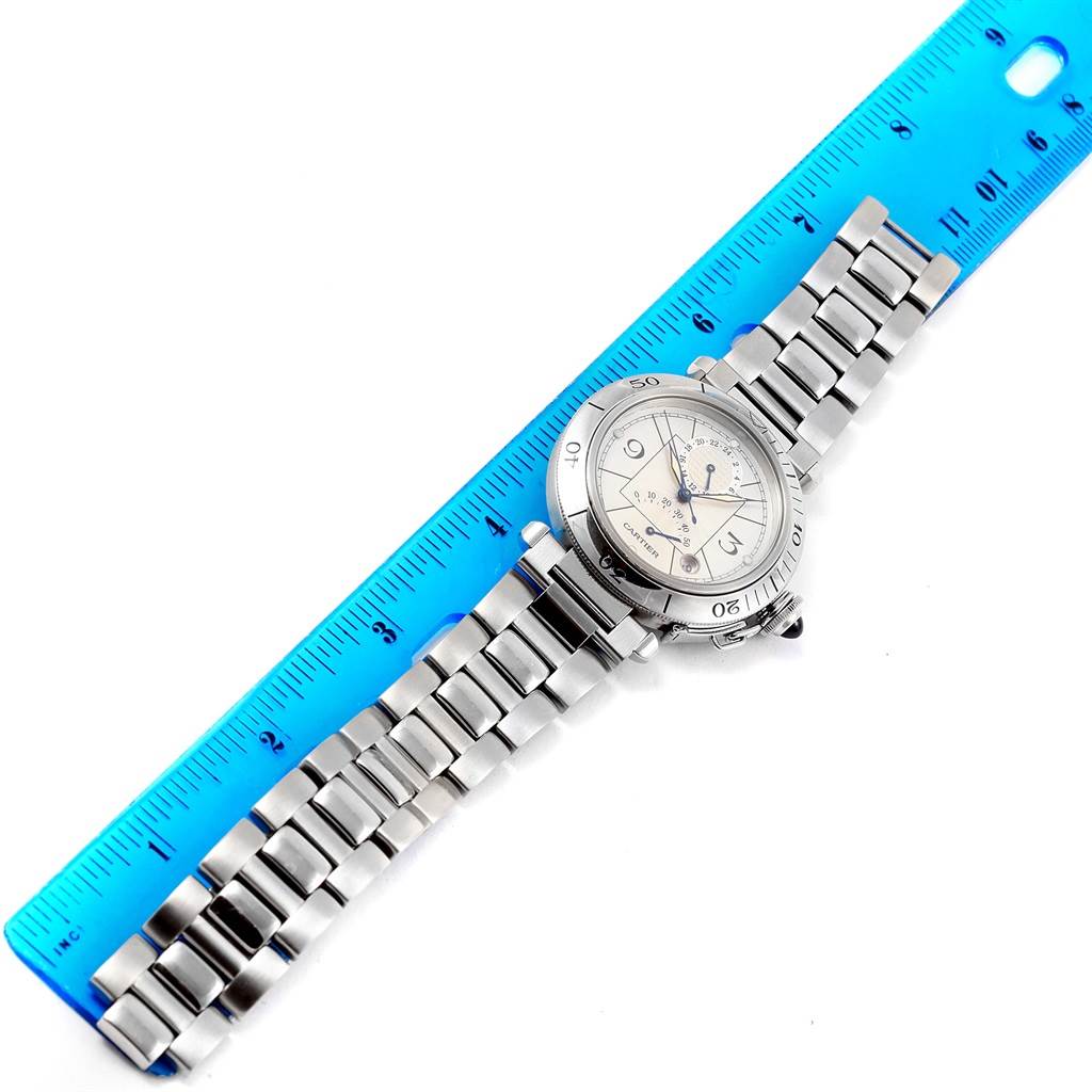 The Cartier Pasha W31037H3 Men's Stainless Steel Silver Dial W31037H3 Men's Stainless Steel Silver Dial watch is shown from a top-down angle, resting by a blue ruler with a metal bracelet visible.