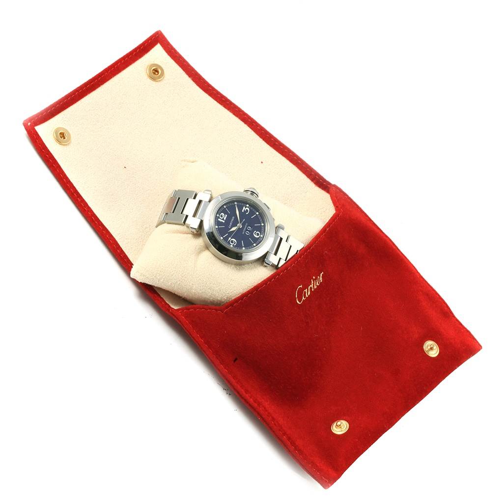 The image shows a Cartier Pasha W31047M7 Men
s Stainless Steel Blue Dial W31047M7 Men
s Stainless Steel Blue Dial watch with a metal bracelet, placed in an open red velvet pouch.