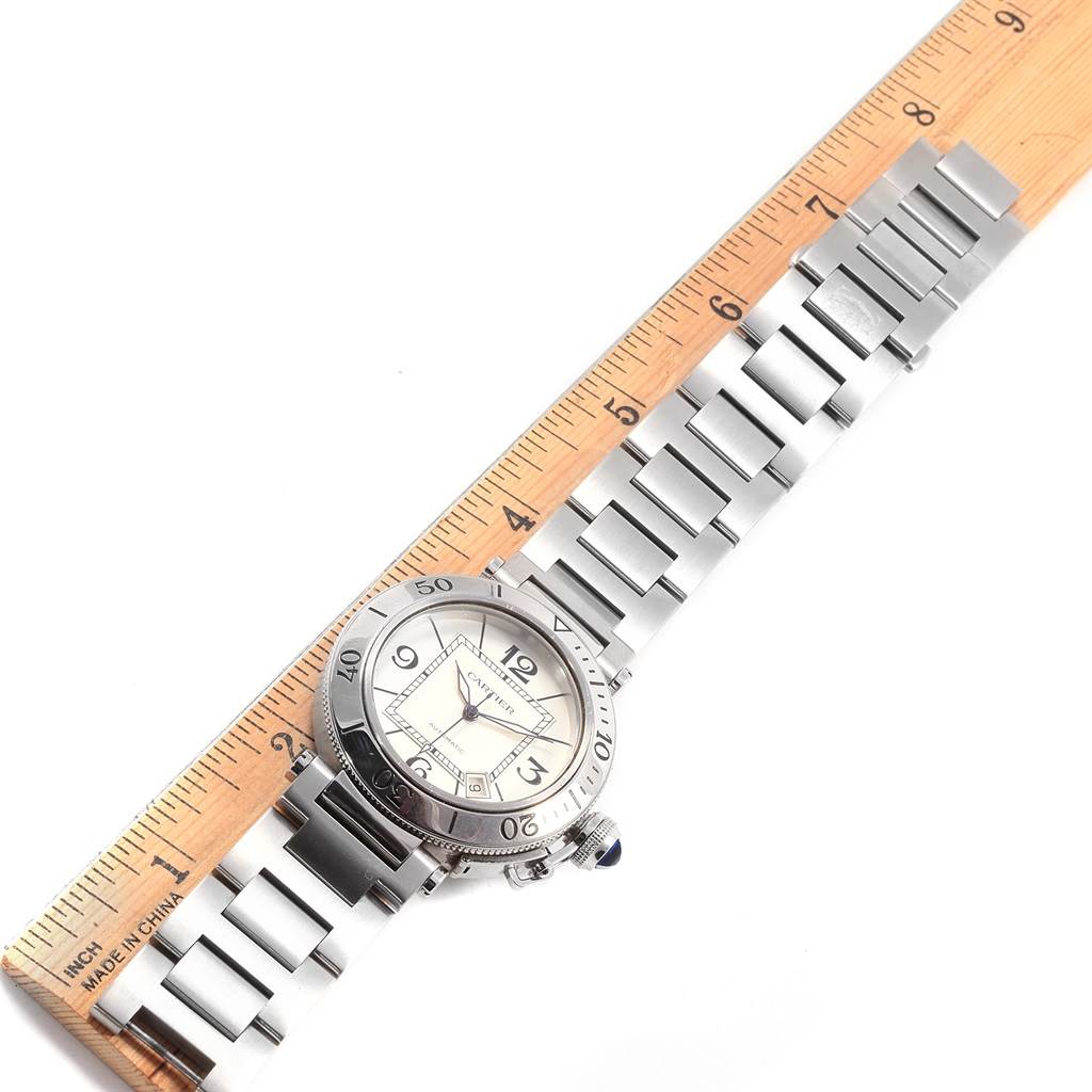 The Cartier Pasha W31080M7 Men
s Stainless Steel Silver Dial W31080M7 Men
s Stainless Steel Silver Dial watch is shown from a top-down angle with the full band and face visible, placed alongside a ruler.