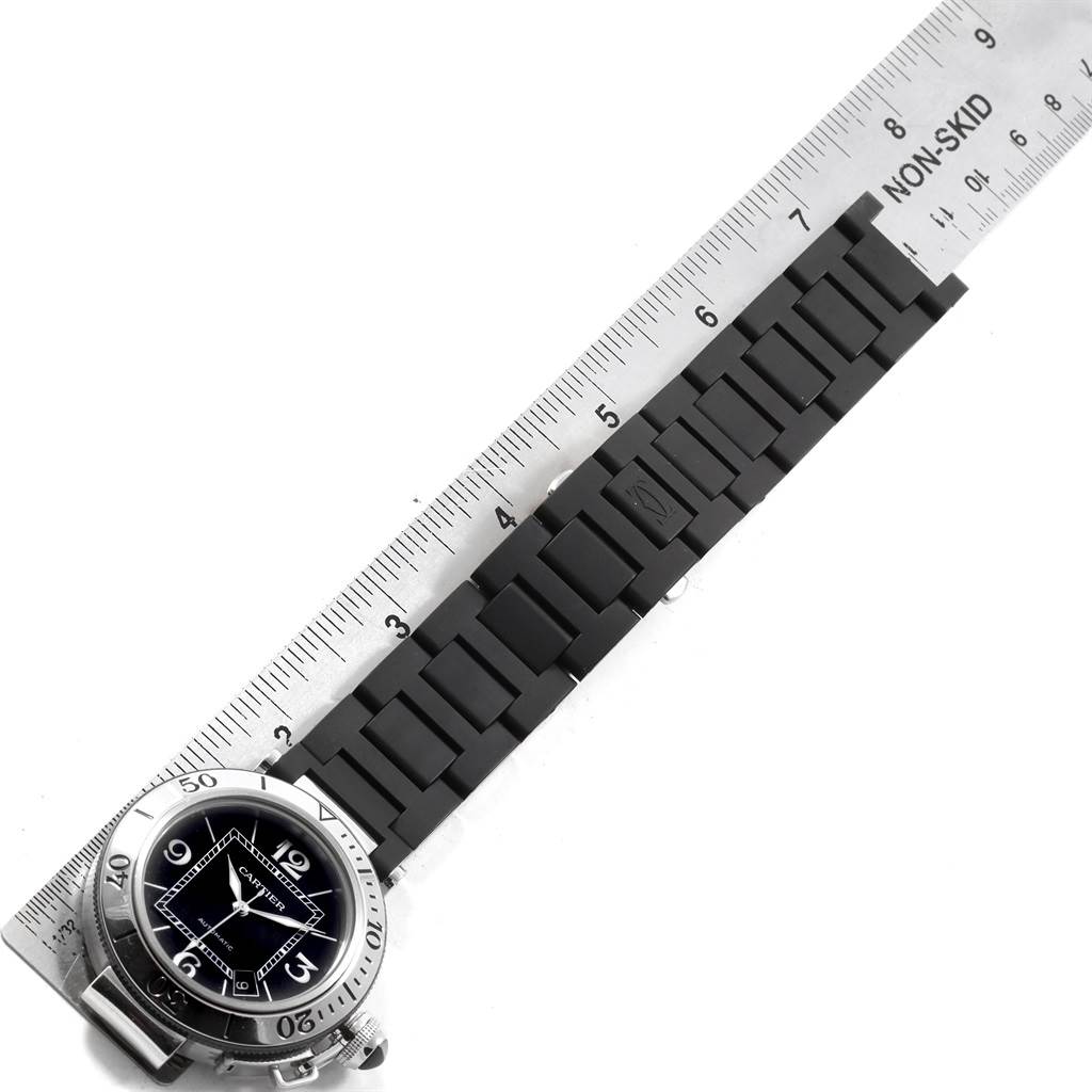 The image shows a Cartier Pasha W31077U2 Men's Stainless Steel Black Dial W31077U2 Men's Stainless Steel Black Dial watch face and its rubber strap, placed next to a ruler for measurement.