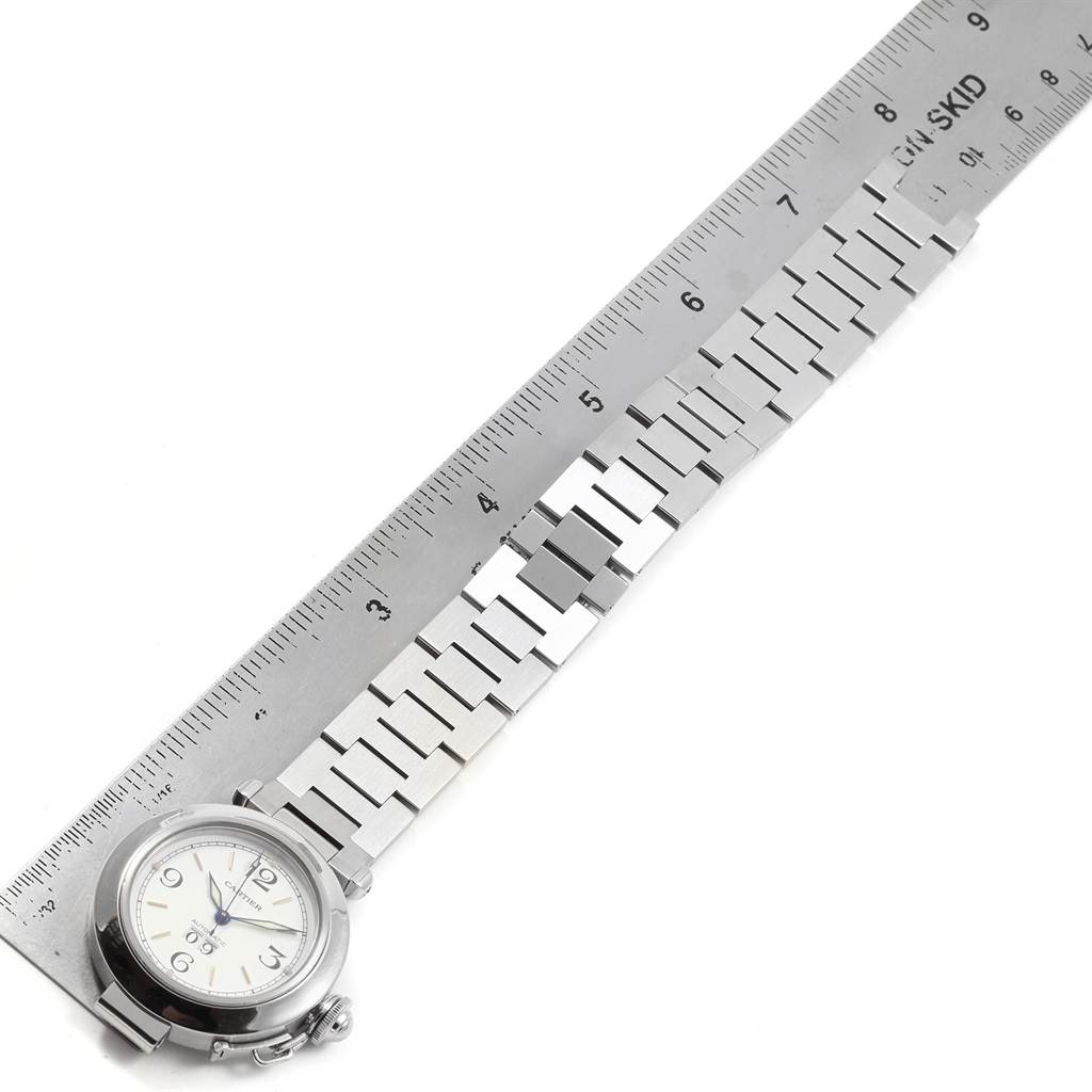 The image shows a Cartier Pasha W31044M7 Stainless Steel White Dial W31044M7 Stainless Steel White Dial watch with a ruler measuring its metal bracelet and face.
