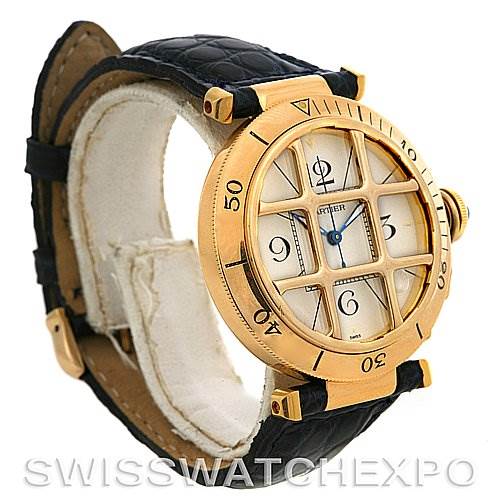 This Cartier Pasha Women's Yellow Gold Silver Dial Women's Yellow Gold Silver Dial watch is shown at a slight angle, revealing its gold case, leather strap, bezel, and distinctive gridded dial.