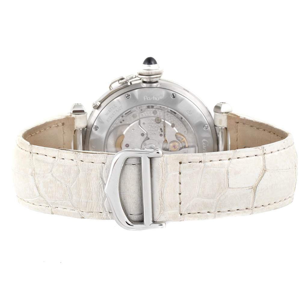 The image shows the back view of the Pasha model by Cartier, highlighting the movement mechanism and white leather strap.
