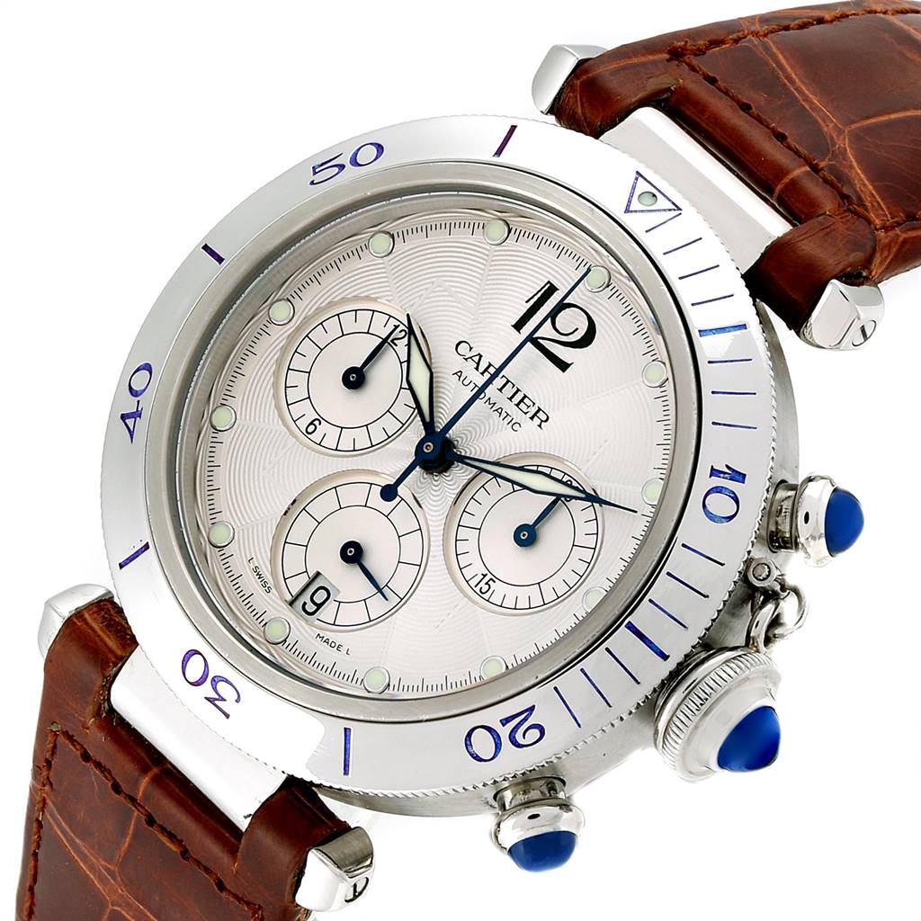 The Cartier Pasha W3103055 Men
s Stainless Steel Silver Dial W3103055 Men
s Stainless Steel Silver Dial watch is pictured at a slight angle, showcasing its brown leather strap, silver bezel, blue accents, and chronograph dials.