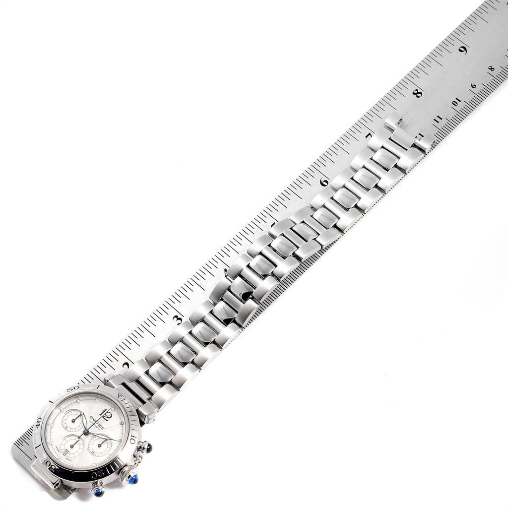 The image shows a Cartier Pasha W31030H3 Men's Stainless Steel Silver Dial W31030H3 Men's Stainless Steel Silver Dial watch placed next to a ruler, displaying its face and metal bracelet from an overhead angle.
