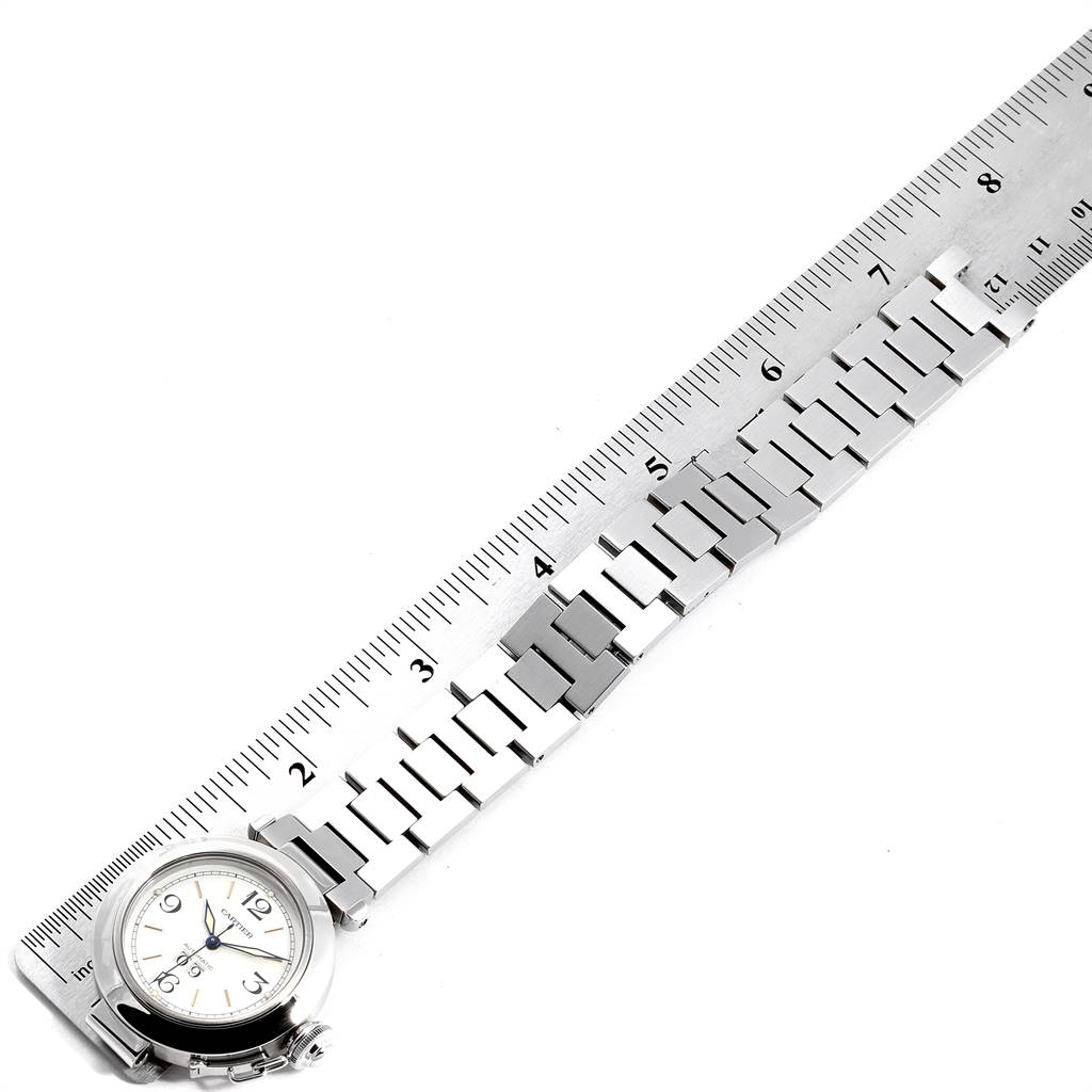 The image shows a top view of the Cartier Pasha W31044M7 Men's Stainless Steel White Dial W31044M7 Men's Stainless Steel White Dial watch aligned with a ruler, focusing on its face and metal bracelet.