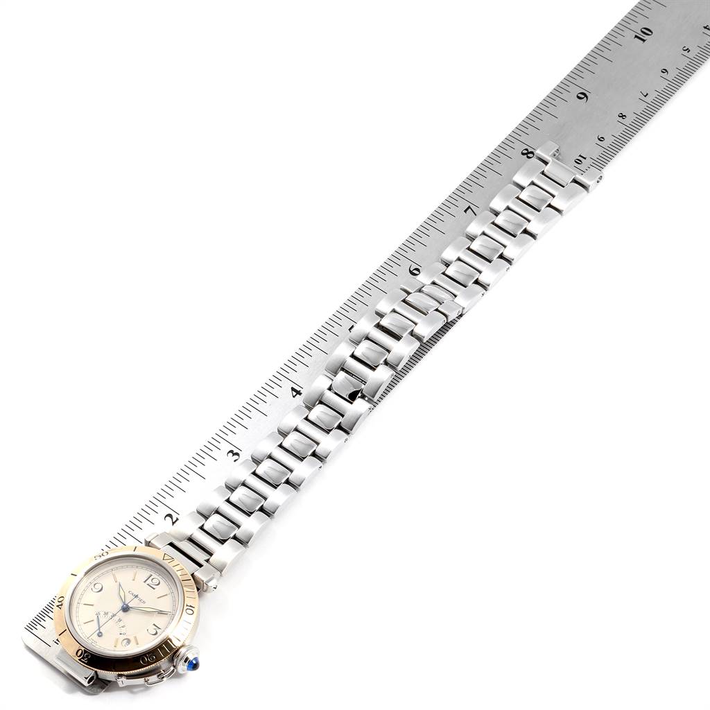 The image shows a top view of a Cartier Pasha W31012H3 Men's Stainless Steel Silver Dial W31012H3 Men's Stainless Steel Silver Dial watch, highlighting the face, bezel, and stainless steel bracelet placed beside a ruler for scale.