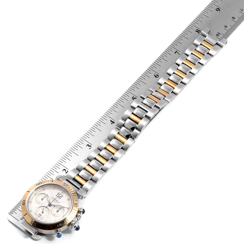 The image shows a Cartier Pasha W31036T6 Men's Stainless Steel Silver Dial W31036T6 Men's Stainless Steel Silver Dial watch at a top-down angle, highlighting the face, bezel, and bracelet next to a ruler for scale.