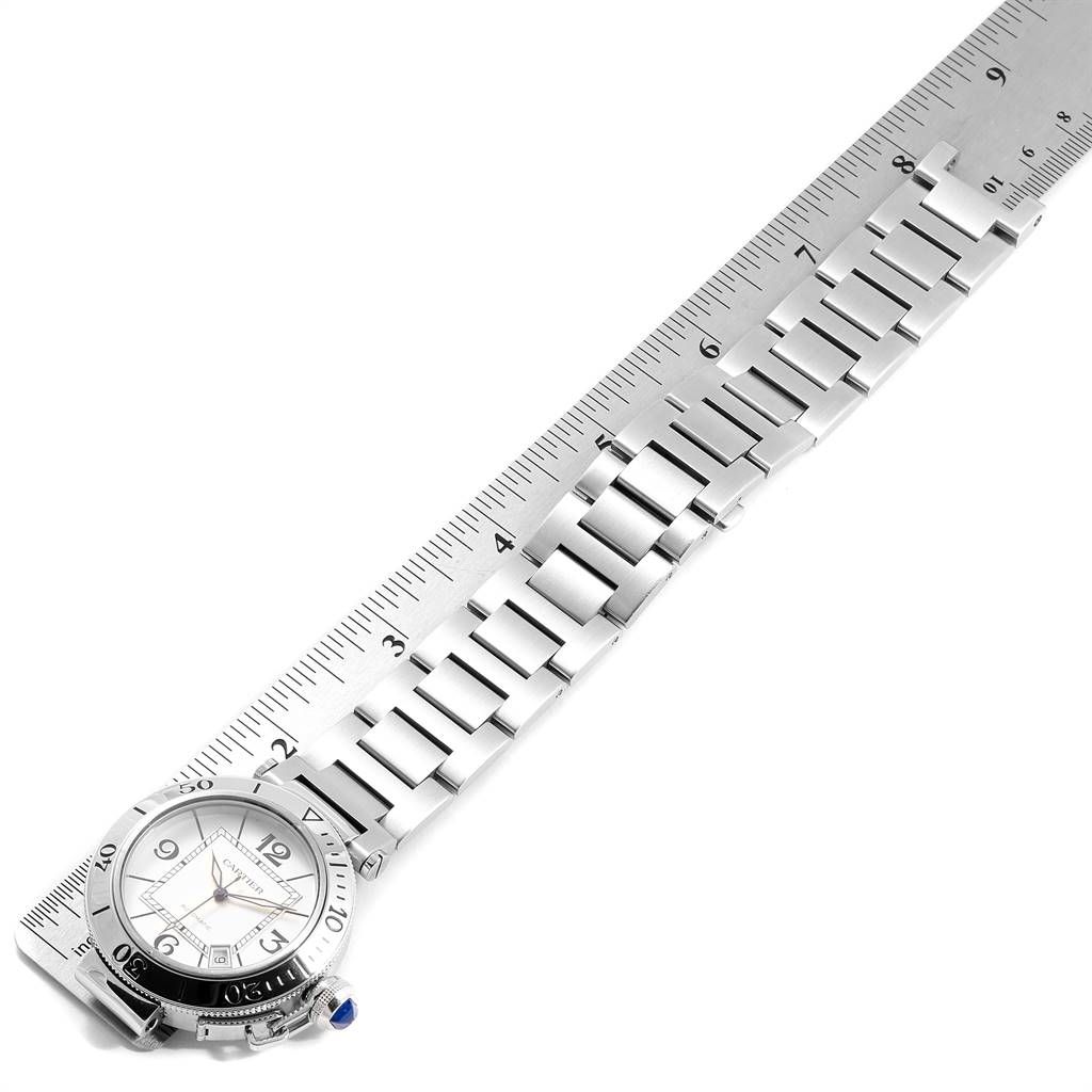 The image shows a Cartier Pasha W31080M7 Men's Stainless Steel Silver Dial W31080M7 Men's Stainless Steel Silver Dial watch laid flat with its metal bracelet aligned alongside a ruler for measurement.