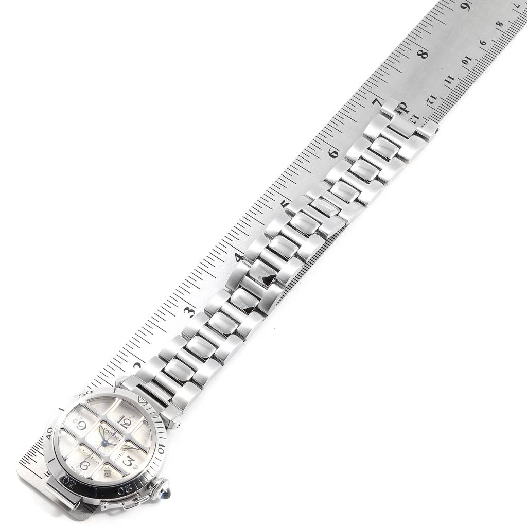 The Cartier Pasha W31059H3 Men
s Stainless Steel Silver Dial W31059H3 Men
s Stainless Steel Silver Dial watch is shown from a top-down angle, displaying the watch face and metal bracelet against a ruler.