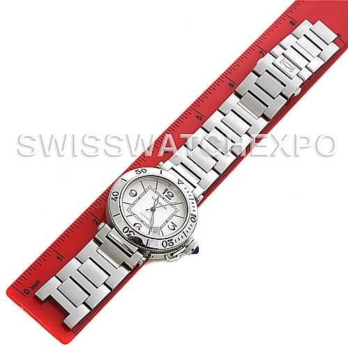 The image shows a Cartier Pasha W31080M7 Men's Stainless Steel White Dial W31080M7 Men's Stainless Steel White Dial watch laid flat with its metal bracelet aligned with a red ruler for scale.