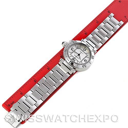 The Cartier Pasha W31080M7 Men
s Stainless Steel White Dial W31080M7 Men
s Stainless Steel White Dial watch is shown from a top-down angle, displaying the face and metal bracelet on a red ruler.