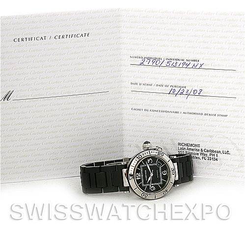 The image shows a Cartier Pasha W31077U2 Men's Stainless Steel Black Dial W31077U2 Men's Stainless Steel Black Dial watch at an angle emphasizing its face and bracelet, with certification documents in the background.