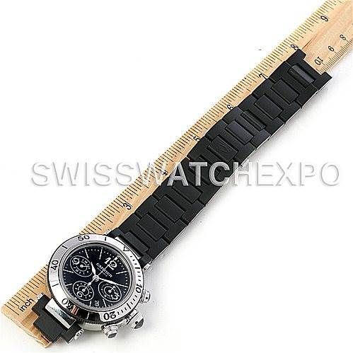 The image shows a Pasha model by Cartier from a top-down view, displaying the watch face and black rubber strap next to a ruler.