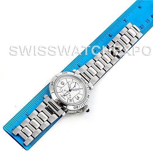 The Cartier Pasha W31037H3 Men
s Stainless Steel Silver Dial W31037H3 Men
s Stainless Steel Silver Dial watch is shown from a top-down angle, displaying its face and metal bracelet beside a blue ruler.